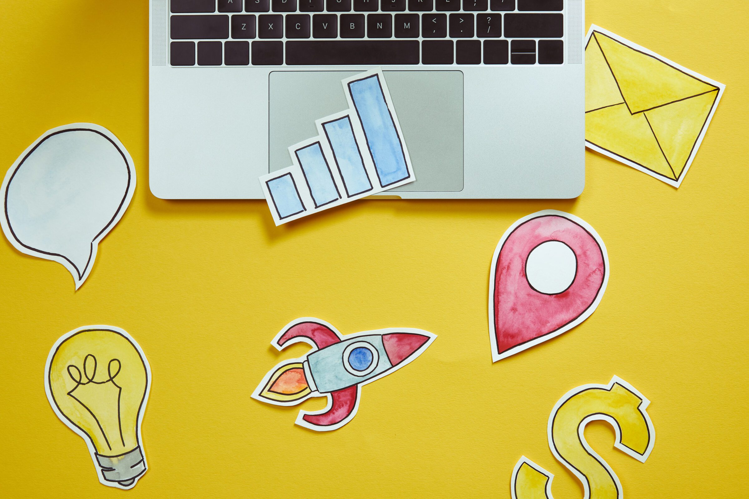 top view of laptop and colored paper signs on yellow surface